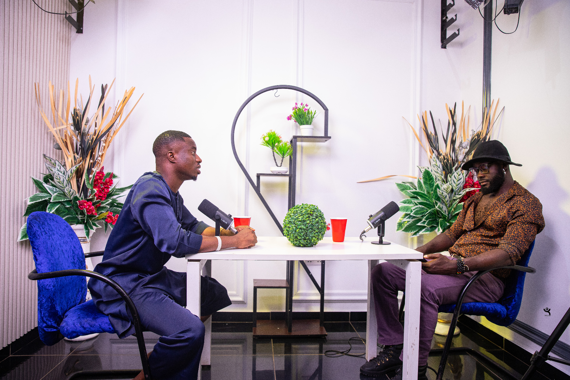 Two guests in a deep conversation across the podcast table